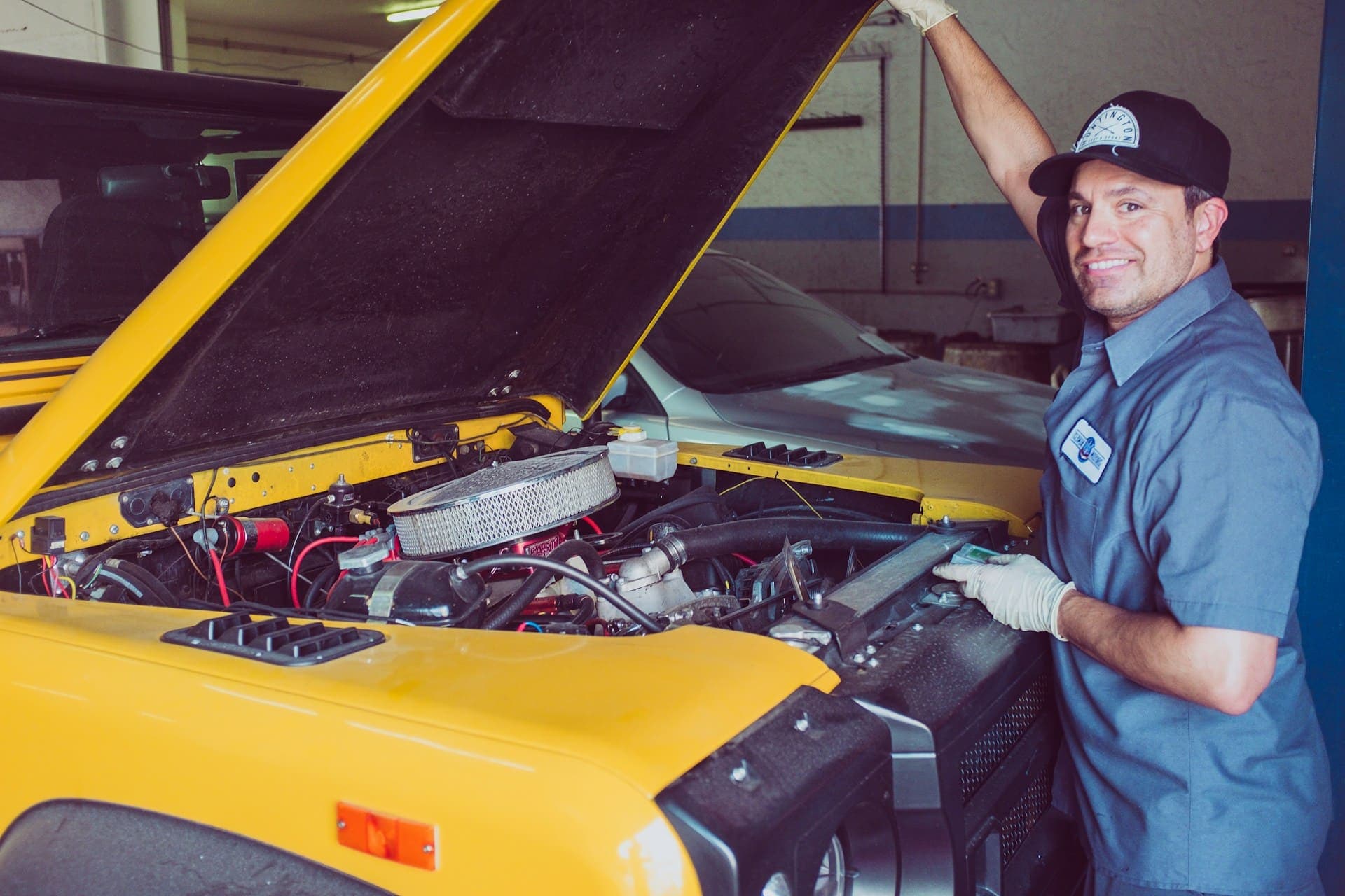 Mechanic working under the hood of a car in an auto repair shop