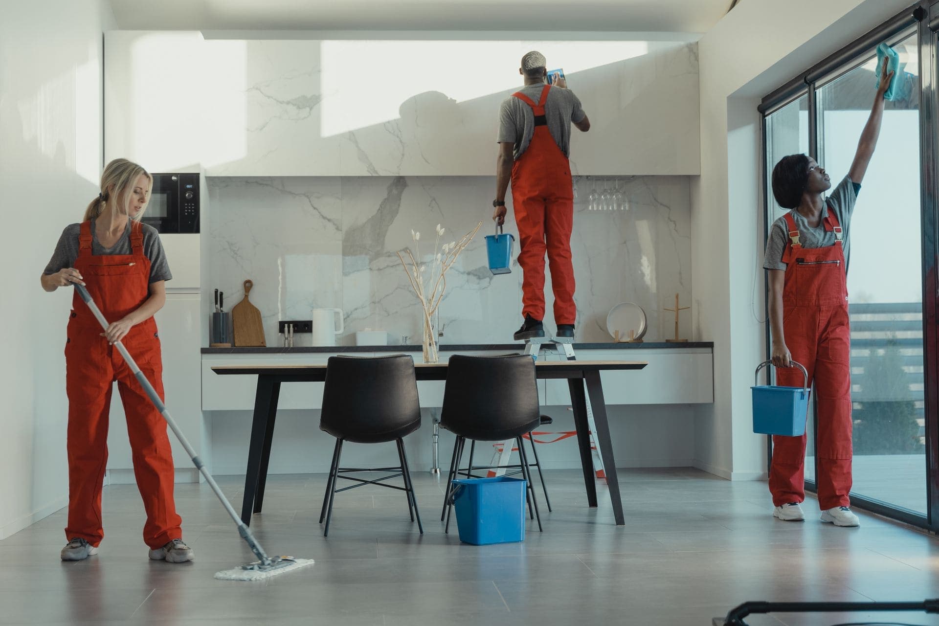 Professional cleaning team working in a bright, modern kitchen